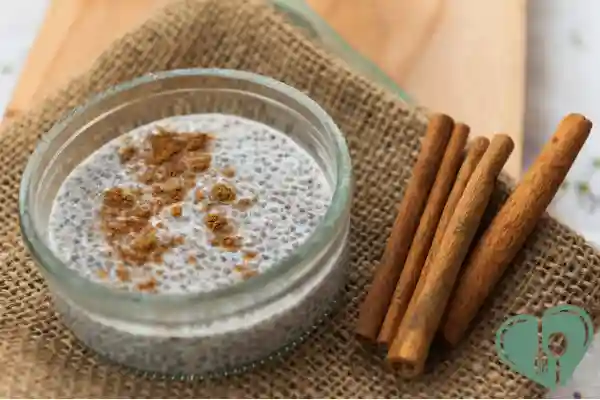 Glass bowl of chia pudding topped with cinnamon, next to whole cinnamon sticks — a fiber-rich diabetic breakfast option.