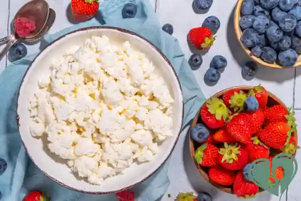 Cottage cheese in a bowl surrounded by fresh strawberries, blueberries, and raspberries — a quick, low-carb diabetic breakfast.