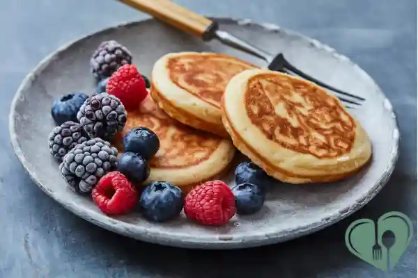 Almond flour pancakes with mixed berries on a ceramic plate