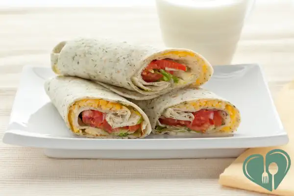 Healthy turkey and veggie wraps for diabetics, filled with cheese, lettuce, and tomatoes.