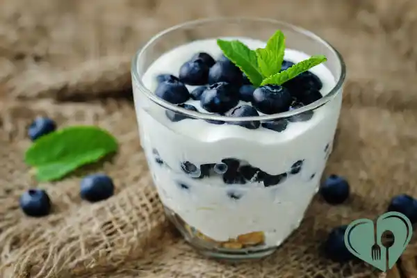 Glass of Greek yogurt parfait with blueberries and mint — a blood sugar-friendly diabetic breakfast option.
