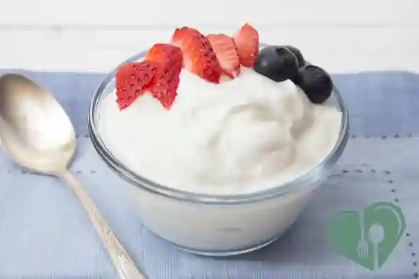 “Plain Greek yogurt in a glass bowl topped with fresh strawberries and blueberries — a low-sugar breakfast option for diabetics”