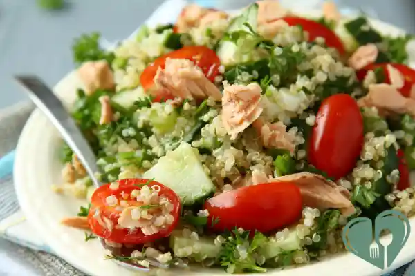 Quinoa salad with cherry tomatoes, cucumber, parsley, and flaked salmon — a Mediterranean meal suitable for diabetics.