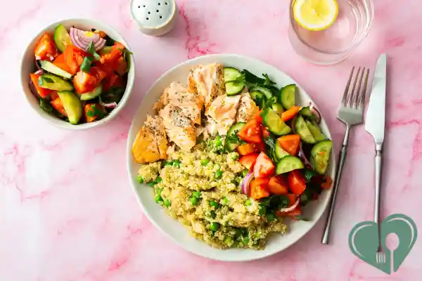 Healthy diabetic lunch plate with baked salmon, quinoa, and fresh vegetable salad.