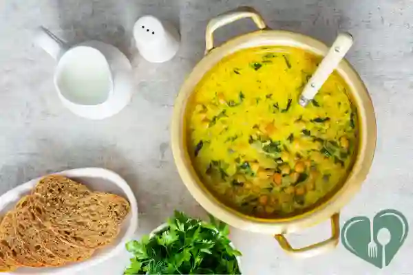 Pot of spinach chickpea soup with herbs and a creamy yellow broth — diabetic-friendly soup.