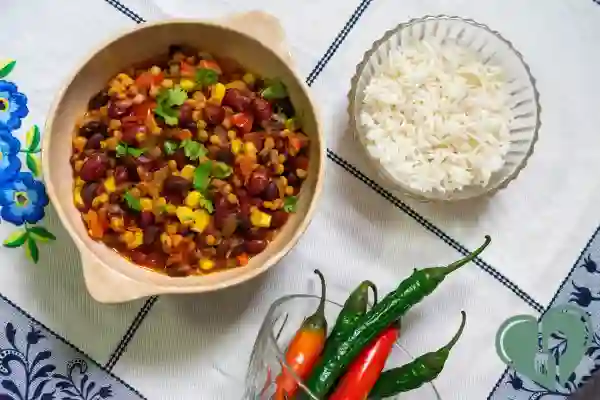 Bowl of three-bean chili with corn and herbs, served with rice — diabetic-friendly pantry dinner.