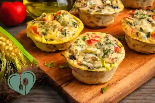 Diabetic-friendly egg muffins with vegetables on a wooden board, ideal for low-carb meal prep breakfasts.