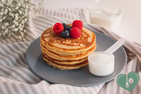 Stack of protein pancakes topped with fresh berries, served on a dark plate — a high-protein, diabetic-friendly breakfast option.