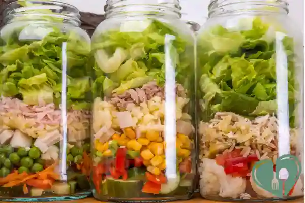 Layered mason jar salads with lettuce, tuna, corn, peas, and vegetables – diabetic-friendly lunch