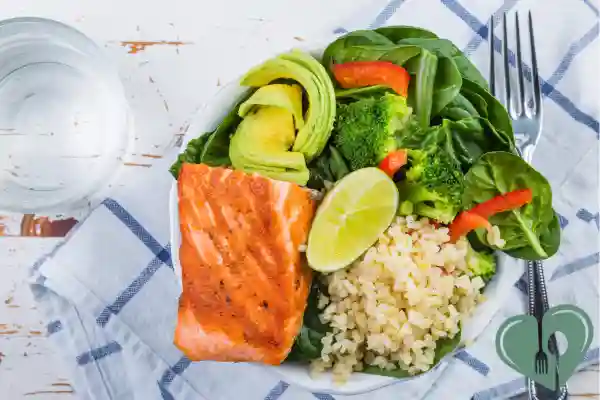 Diabetic-friendly bowl with grilled salmon, avocado, broccoli, spinach, and brown rice