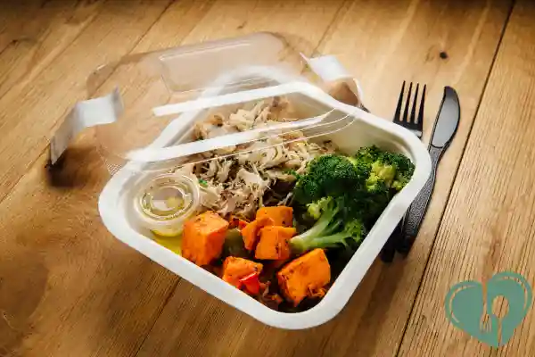 Balanced store-bought diabetic lunch with shredded chicken, broccoli, and roasted sweet potatoes in a takeout container.