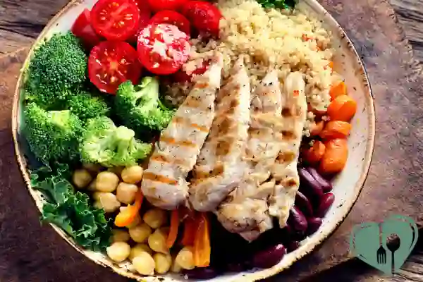 Colorful whole food diabetic lunch plate with grilled chicken, quinoa, chickpeas, beans, and fresh vegetables