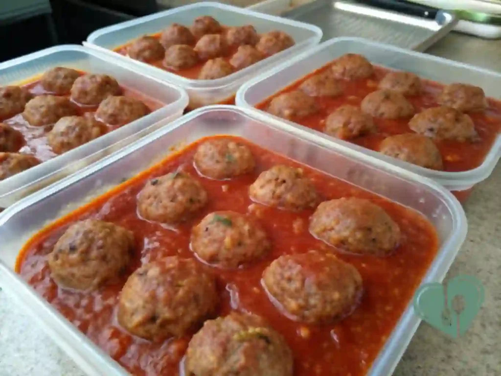 Turkey meatballs in tomato sauce stored in freezer-safe containers, diabetic-friendly high-protein crockpot meal prep.