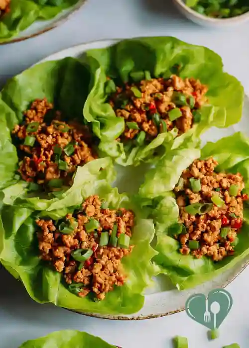 Turkey lettuce wraps filled with seasoned ground turkey and green onions on a plate