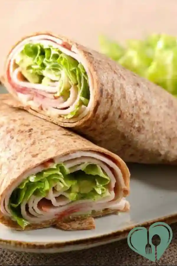 Turkey avocado wraps with fresh ingredients served on a wooden table