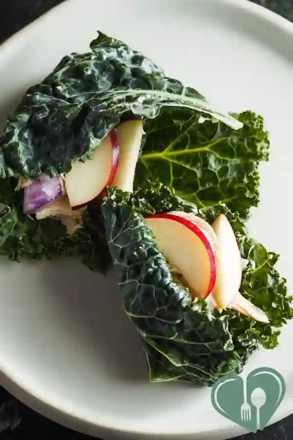 Chicken apple kale wraps with fresh ingredients in a soft tortilla on a simple plate