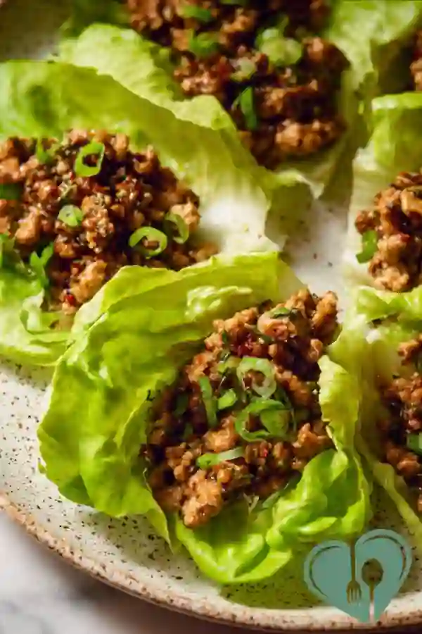 Chicken lettuce wraps with fresh ingredients on a simple plate