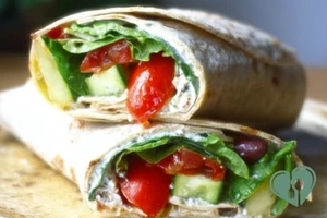 Close-up of a Greek salad wrap loaded with crunchy vegetables and creamy feta filling