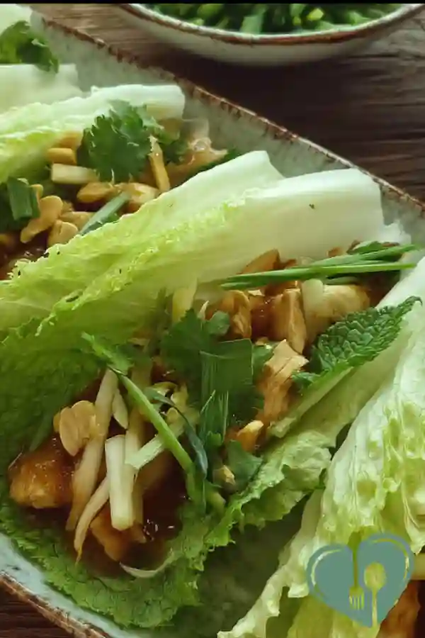 Peanut chicken cabbage wraps with fresh vegetables in a soft tortilla on a simple plate