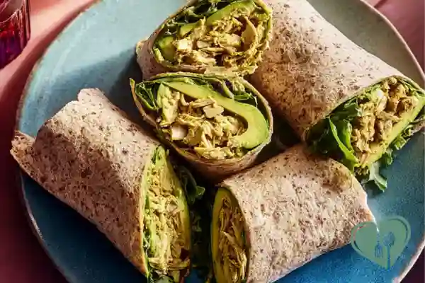Turmeric chicken avocado wraps with fresh ingredients served on a wooden table